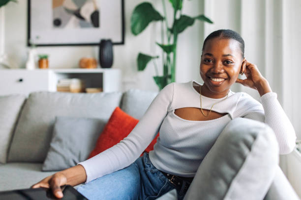 istock Joyful woman relaxing on couch at home 2147633499