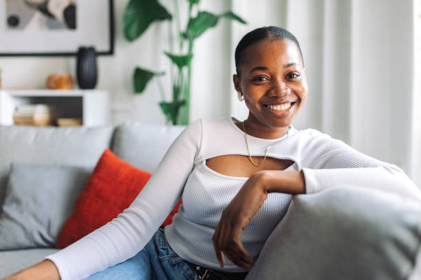 istock Smiling woman relaxing on sofa at home 2147633548