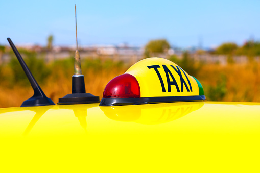 Taxi sign atop the car. Yellow cab top