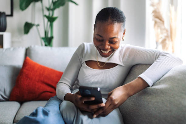 istock Cheerful woman using smartphone at home 2147634206