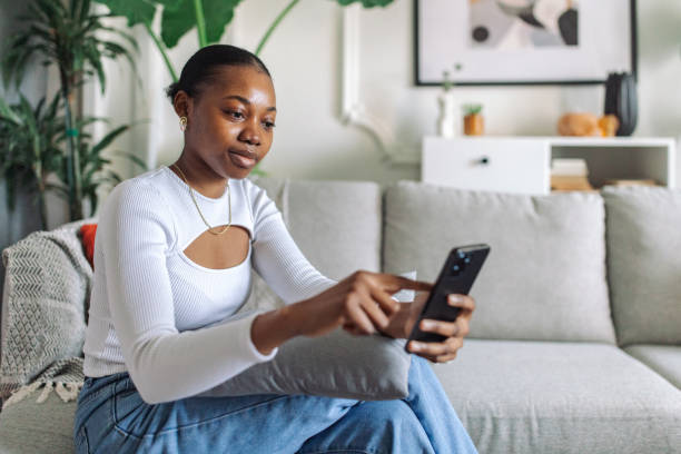 istock Serene young woman using smartphone at home 2147634537