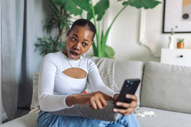 istock Surprised woman checking phone at home 2147634563