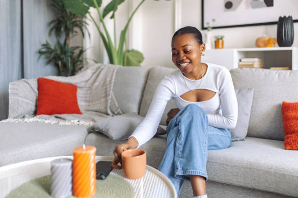 istock Joyful woman relaxing on a couch at home 2147635450