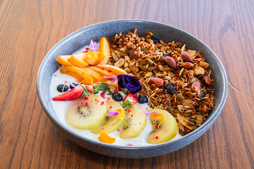 Table top of bowl of Roasted Muesli with fruit.