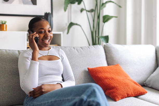 istock Joyful woman talking on phone at home 2147635511