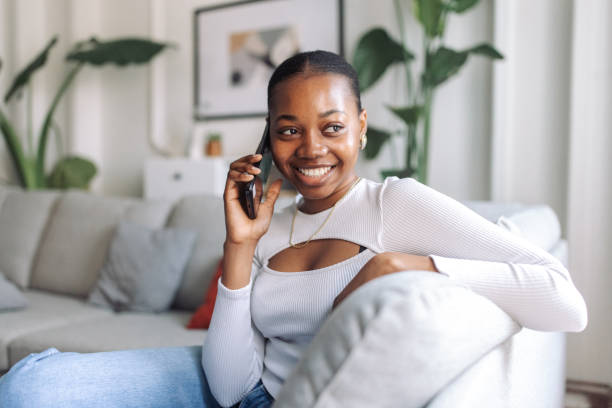 istock Smiling black woman relaxing on a couch at home 2147635703