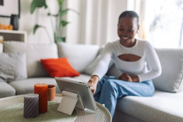 istock Cheerful black woman relaxing on sofa at home 2147635889