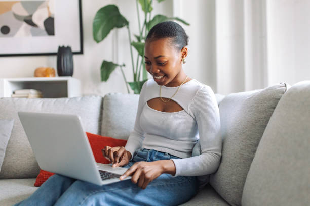 istock Smiling woman working on laptop at home 2147636482