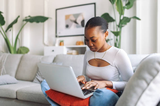 istock Focused black woman working on laptop at home 2147636588