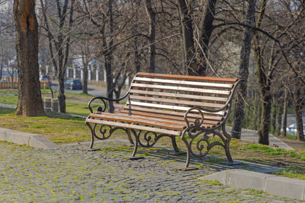 Wooden Bench With Cast Iron at Town Park Sunny Spring Day in Craiova Romania