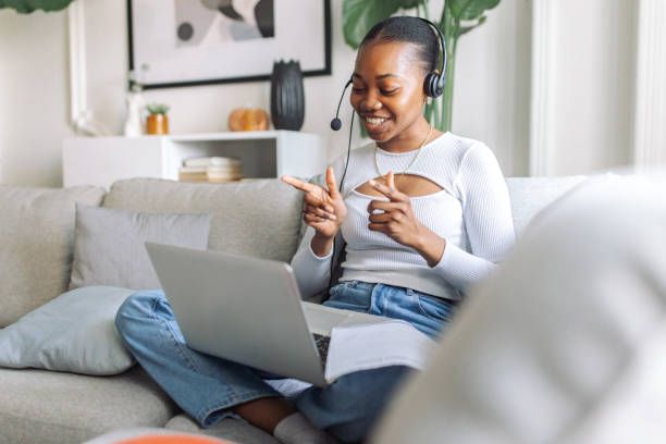 istock Smiling woman with headset using laptop at home 2147639447