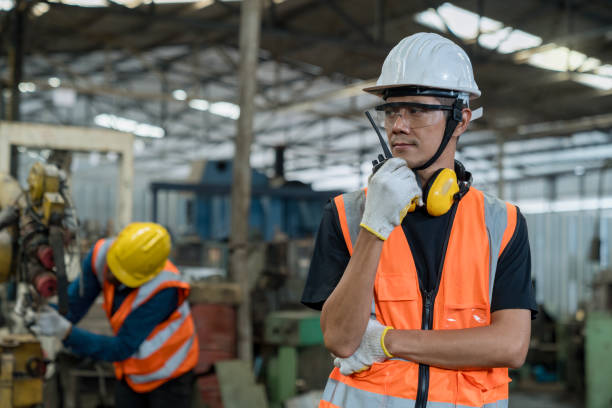 istock Industrial worker in factory with walkie talkie transmitter. The technician is working in a steel factory. 2147640766
