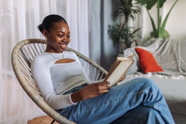 istock Young woman enjoying reading at home 2147642359