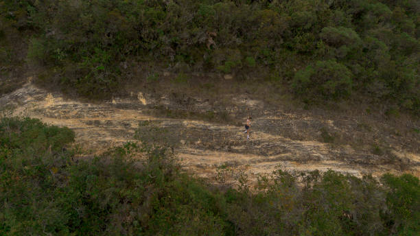 woman running across a mountain, general drone shot.