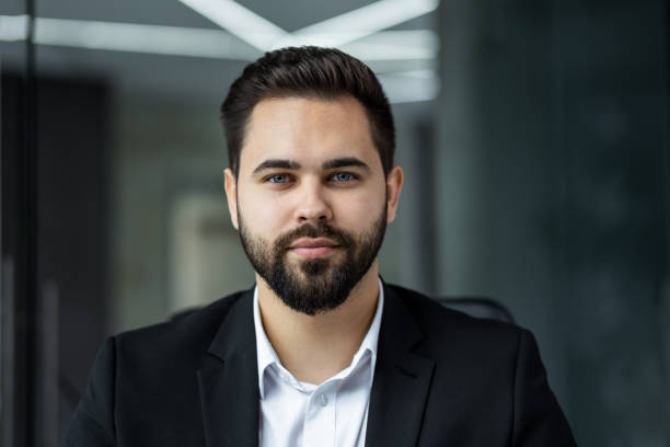 istock Good-looking millennial office boss or manager sitting at desk looking at camera. Successful worker, career advance and opportunity, owner of prosperous business concept 2147648749