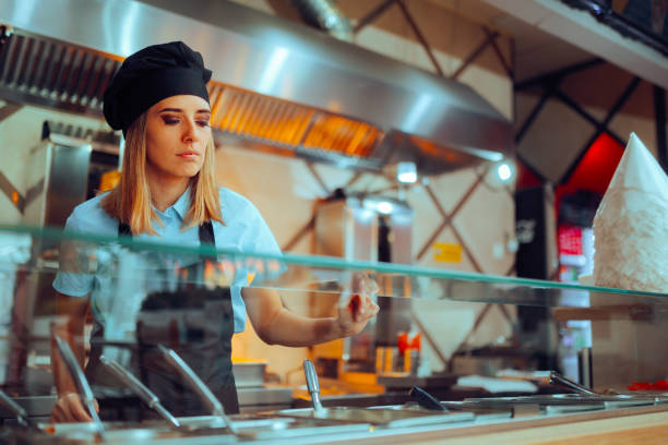 istock Fast Food Chef Working Behind a Counter Preparing Sandwiches 2147649069