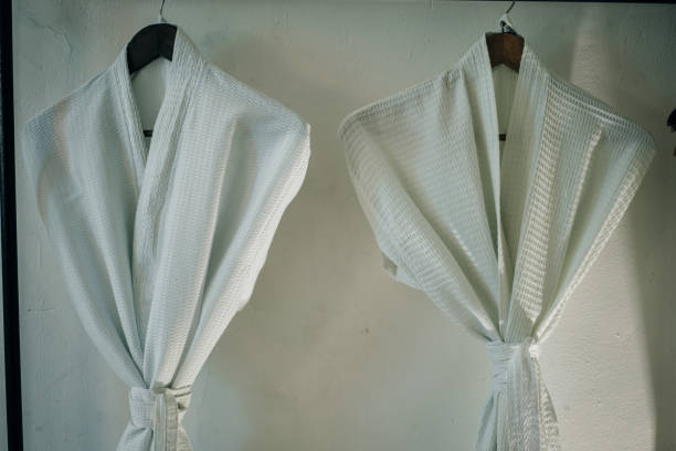 istock Fresh white bathrobes hanging on rack indoors 2147650023