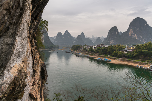 View of the Li River (Lijiang River) with azure water among scenic karst mountains at Yangshuo County of Guilin, China. Green hills on blue sky background. Amazing summer sunny landscape.