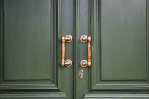 istock Green door with yellow handles , close up 2147655365