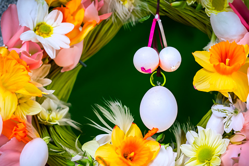 Easter composition of the branches,Easter colored eggs and flowers for the holiday on the wooden background . High quality photo