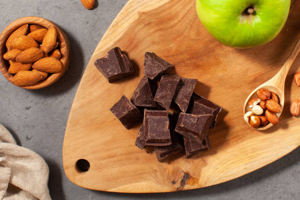 Cubes of dark artisan chocolate. Dark chocolate chunks with almonds and fresh apples