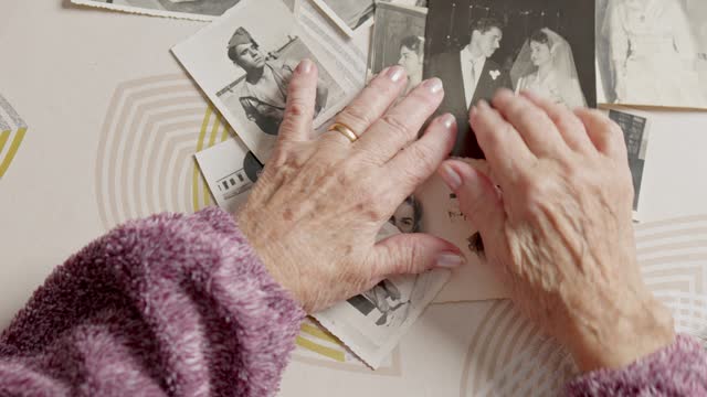 point of view of elderly woman looking at vintage black and white family photos