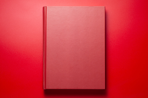 A red book on red background, Top view.