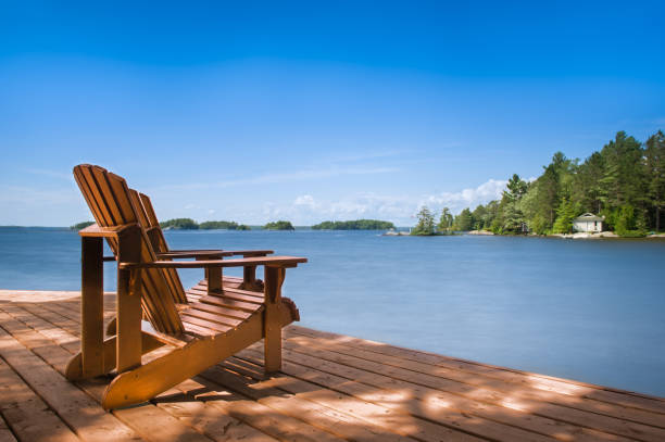 istock Two Adirondack chairs grace a wooden dock 2147663063