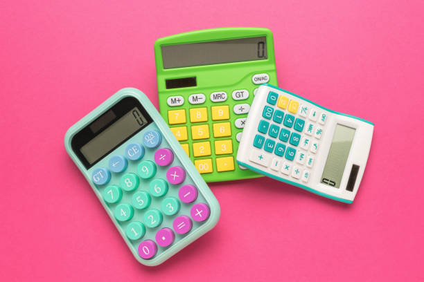 istock Three calculators lying on top of each other on a red background. 2147664020