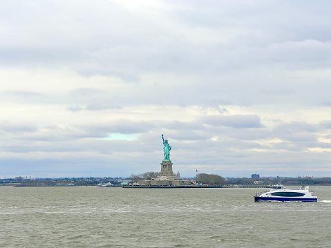 Ferry boat passing by in front of Statue of Liberty in New York City