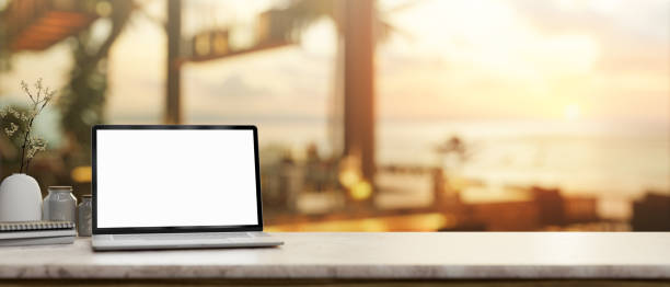 istock A laptop mockup on a tabletop, with a blurred background of a beachfront hotel lounge or restaurant. 2147668896