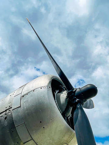Propeller blades of a vintage aircraft against a cloud filled sky