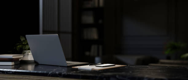 istock A close-up image of a laptop computer on a dark marble desk in a modern dark office. 2147669672