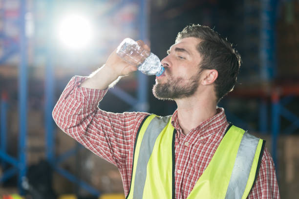 istock Warehouse male worker drinking water in break time in warehouse storage. Male worker drinking water in warehouse 2147669699