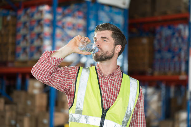 istock Warehouse male worker drinking water in break time in warehouse storage. Male worker drinking water in warehouse 2147669702