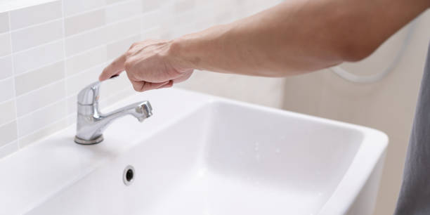 istock Save water. Man keeps turning off the running water in the bathroom to protect environment. Greening planet, reduce global warming, Save world, life, future, risk energy, crisis , water day. 2147669990