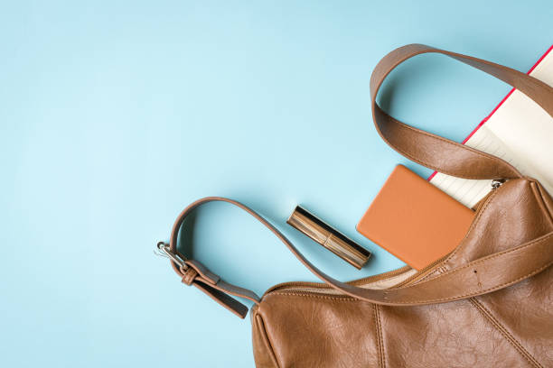 Woman handbag with phone, lipstick and notepad.