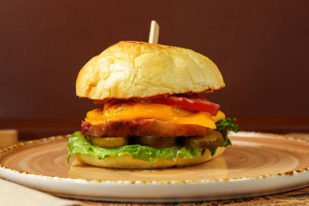 istock Cheeseburger is beef patty, melted cheese, fresh lettuce, and ripe tomato are clearly visible. 2147671345