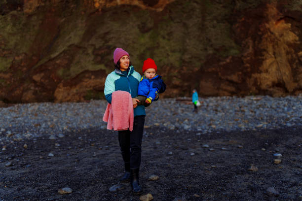 istock Mother holds toddler boy while walking at the coast in winter 2147671385