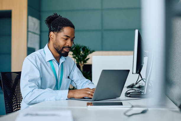 istock Smiling black businessman working on laptop in the office. 2147672960