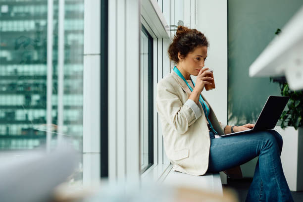istock Businesswoman drinking coffee while working on laptop in the office. 2147673018