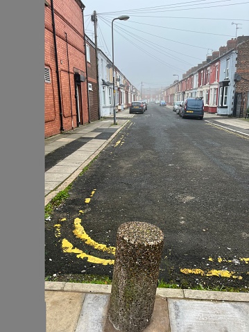 View of a street in Liverpool. Stone stop pillar in foreground.