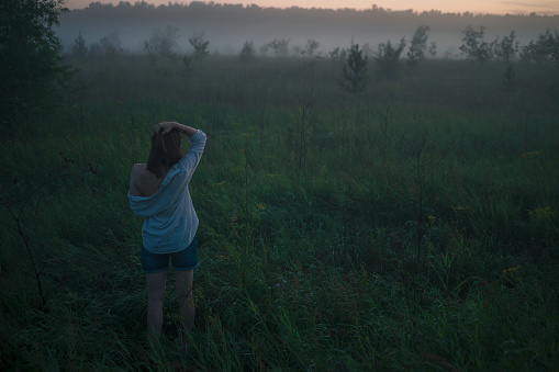 Woman in a field with misty fog