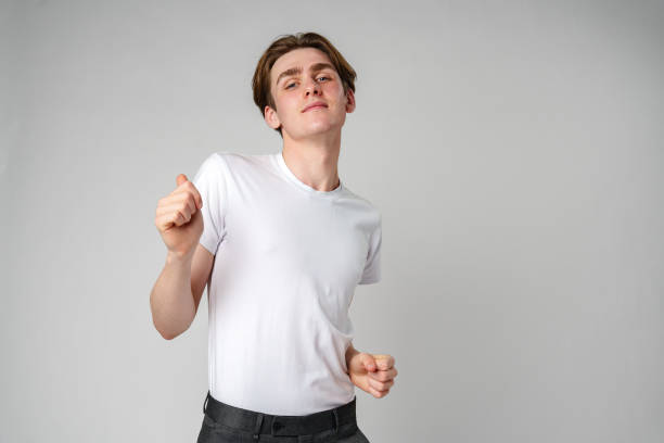 istock Young Man in Casual Attire Dancing Alone in a Studio Setting 2147677962