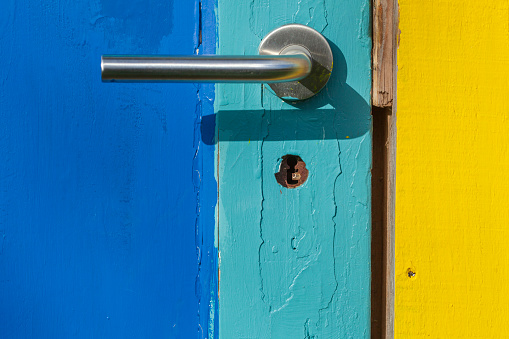 Door handle on a colorful wooden door, Germany
