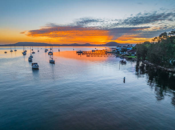 istock Sunrise over the water with boats and reflections 2147678832