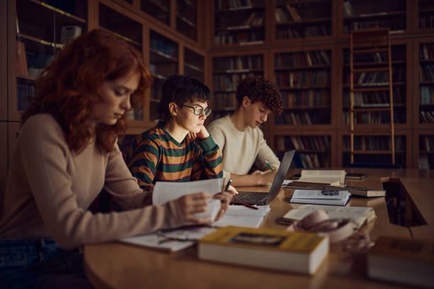 istock Group of high school students studying in library. 2147679438