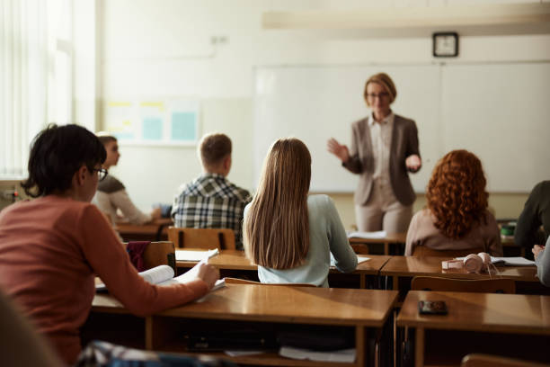istock Back view of high school students listening to their teach on a class. 2147679610