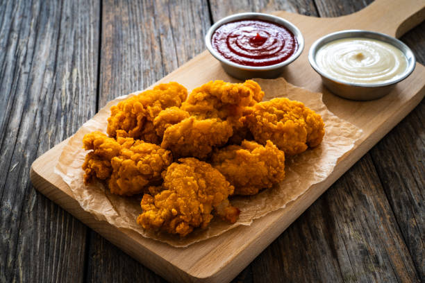 istock Fried chicken nuggets and ketchup on wooden background 2147679777