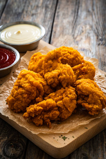istock Fried chicken nuggets and ketchup on wooden background 2147679907